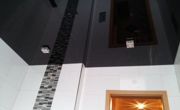Dunkle Lackspanndecke mit Mosaik-Akzentstreifen im Badezimmer – Beispiel für Spanndecken in Hennef und Umgebung