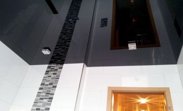 Dunkle Lackspanndecke mit Mosaik-Akzent und Designer-Spots im Badezimmer – Beispiel für Spanndecken in Minden und Umgebung