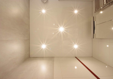 Badezimmer mit weißer Spanndecke und integrierten Einbaustrahlern für elegante Beleuchtung.