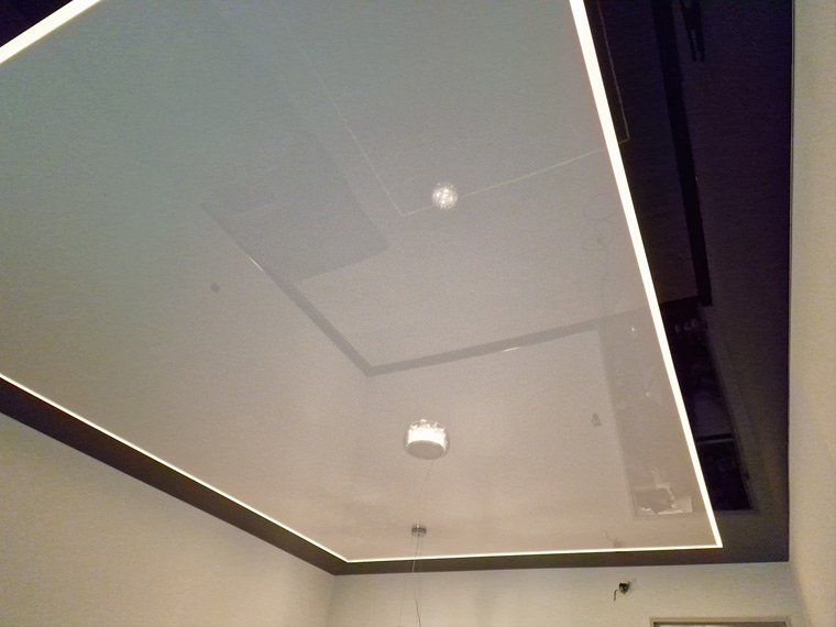 Белый глянцевый натяжной потолок с LED-подсветкой по периметру и тёмной рамой